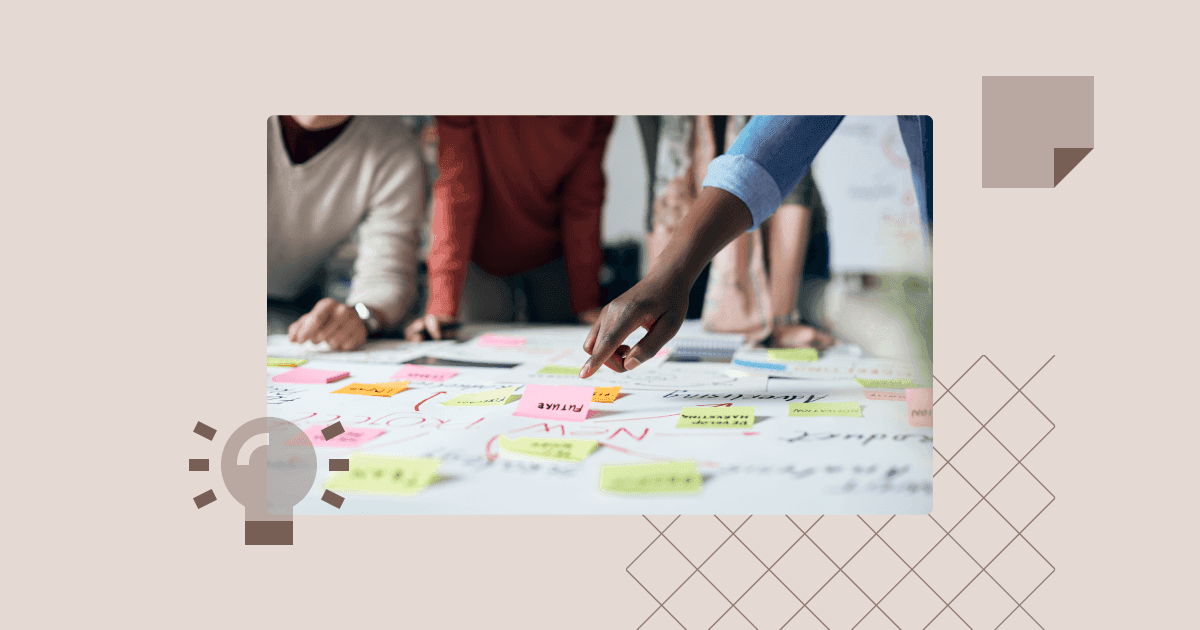 Close-up of team members placing sticky notes on a table during a strategic brainstorming session.