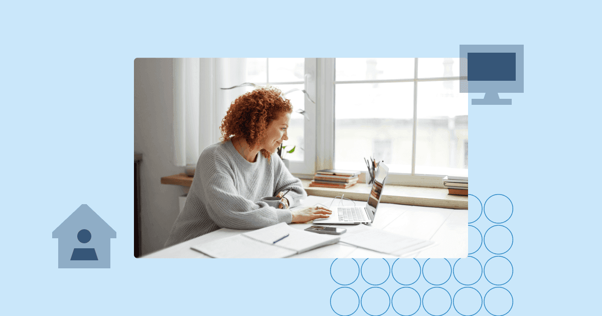 Woman working on a laptop at a bright home desk near a window, managing daily tasks remotely.
