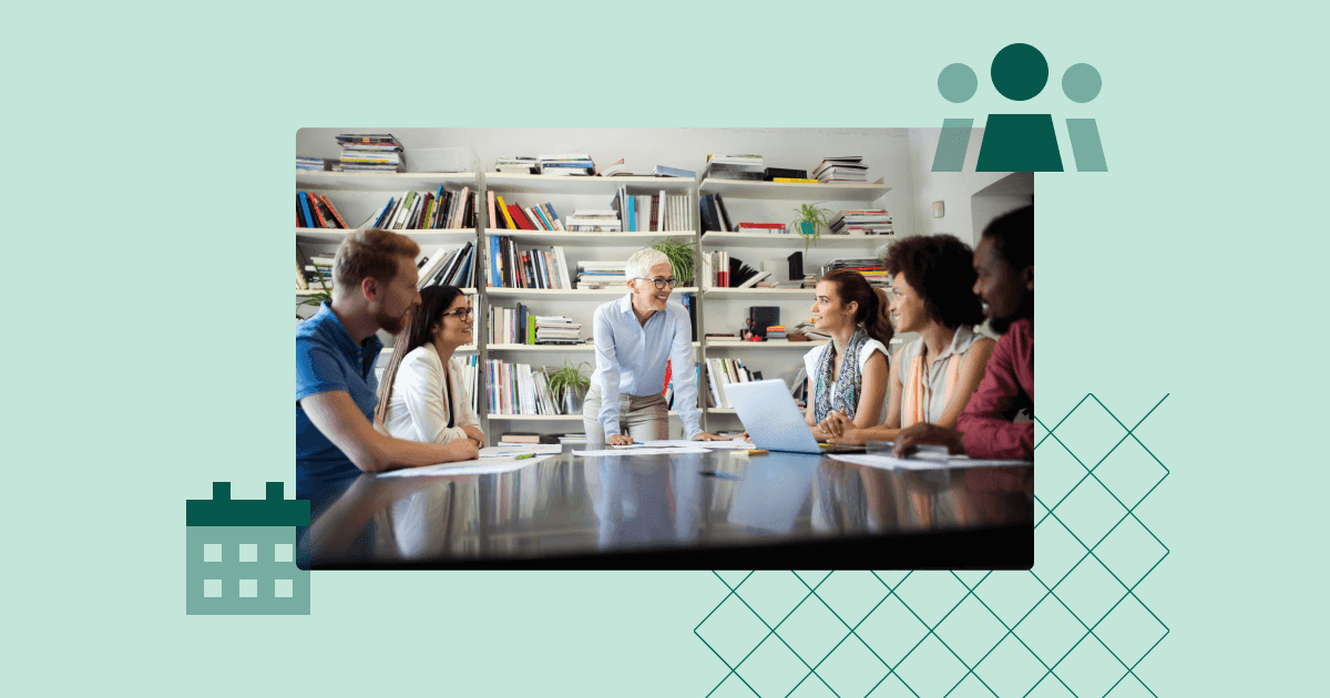 Team seated around a table listening to a senior manager leading an interactive group meeting.