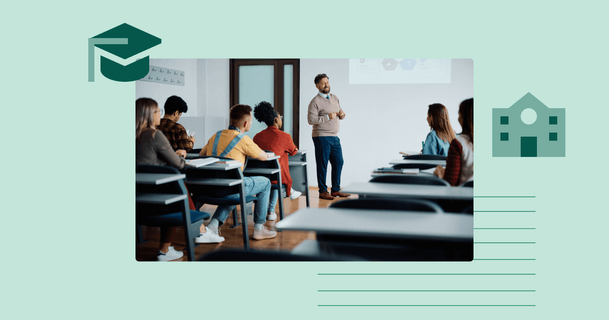 Lecturer speaking in front of students seated at desks in a university classroom setting.
